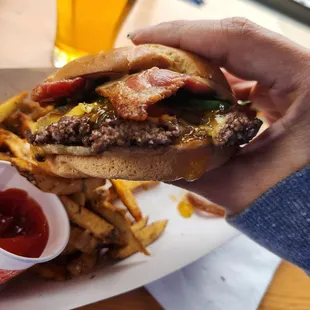 a person holding a hamburger and fries