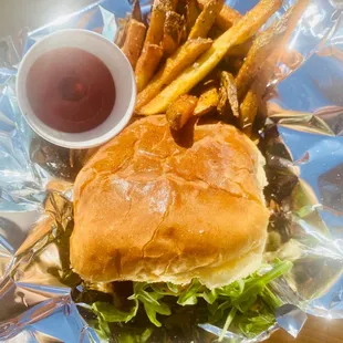 The "Green Jacket" {Fried green tomato, roasted red peppers, pimento cheese, arugula, truck-made garlic aioli} with a side of fries.