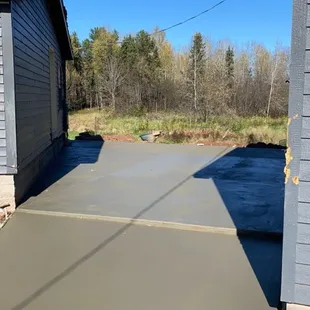 30+ yard driveway pour with a conveyor. slope away from the house on the edges, flat spot inbetween house and garage for building on.