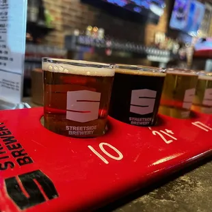 A flight of 4 beers, sitting at the bar
