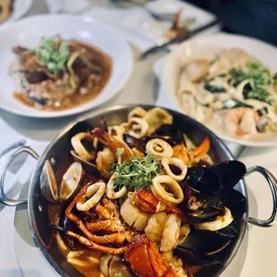 a bowl of seafood and pasta on a table