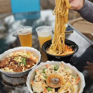 a person holding a fork over a bowl of noodles