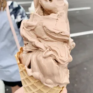 a person holding a cone of ice cream