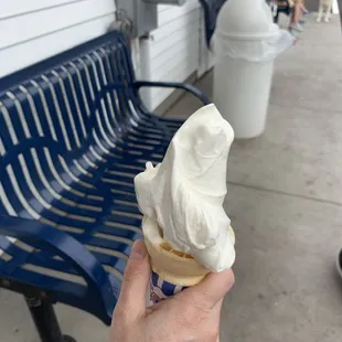 a hand holding an ice cream cone