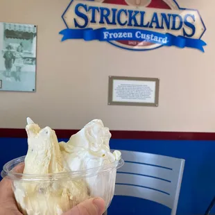 a hand holding a cup of ice cream