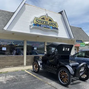 an old car parked in front of a store