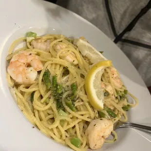a plate of pasta with shrimp and peas