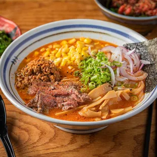 a bowl of ramen with meat and vegetables