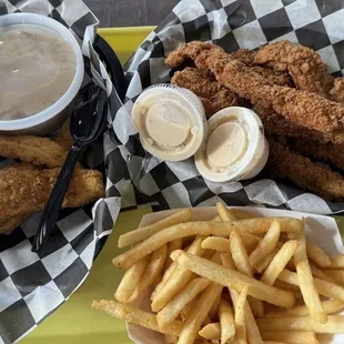 Chicken tenders with mashed potatoes on the left. Pork tenderloin strips with fries on the right.