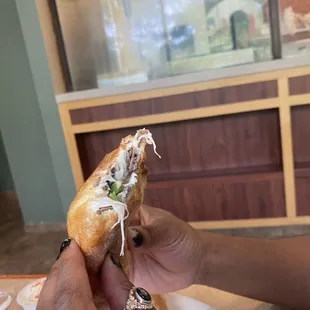 a person holding a sandwich