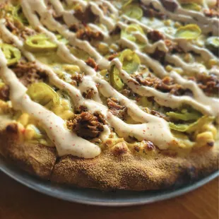 El Muchacho Seasonal pie. Street Corn base, tender Barbacoa, Jalapenos, topped with Tajin Crema.