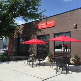 the outside of a restaurant with tables and umbrellas