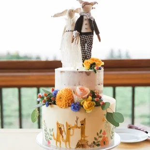 Naked cake with a hand-painted fondant base that matches our invitation design