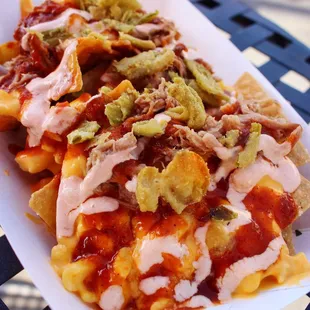 Space Junk Nachos - topped with pulled pork, mac and cheese, BBQ sauce, chipotle crema and fried jalapeños. $8.49, limited time.