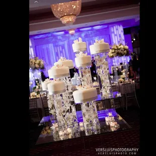 Small cakes on glass cylinders filled with white orchids