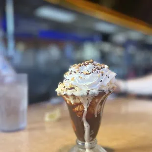 a chocolate sundae with whipped cream and sprinkles