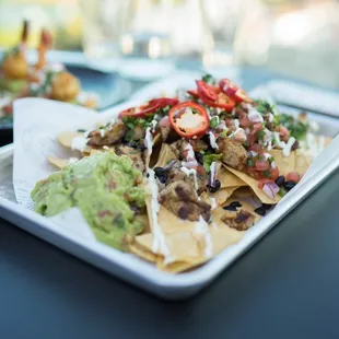 Mine, Not-Chos  House Fried Tortilla Chips, Queso Blanco, Cheddar, Pico de Gallo, Guacamole, Black Beans, Cilantro Lime Crema
