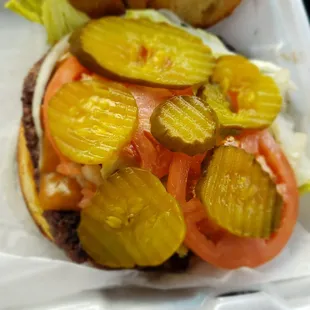 a sandwich with pickles and tomatoes