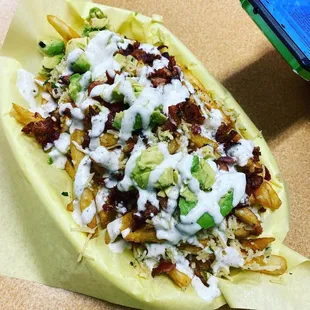Loaded garlic fry basket topped with bacon avocado and ranch.