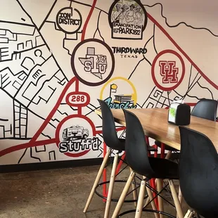 a table with chairs and a map on the wall