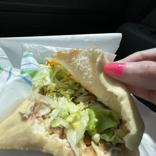 a hand holding a sandwich