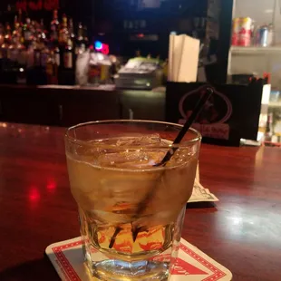 a drink in a glass on a coaster