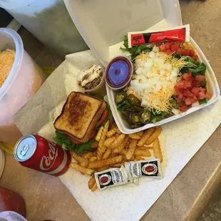 a sandwich, fries, salad and soda