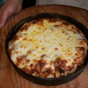 Pan pizza fresh from the oven, still in the pan.
