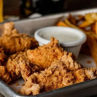 a tray of fried chicken and fries