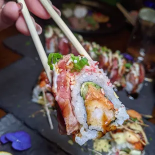 a hand holding a piece of sushi
