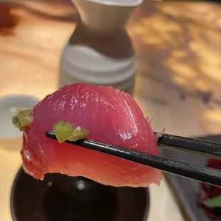 a piece of sushi being held by chopsticks