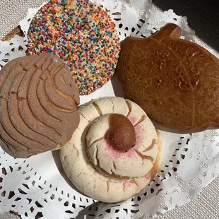 Chocolate concha, a vanilla concha, piggy, cookie with sprinkles.