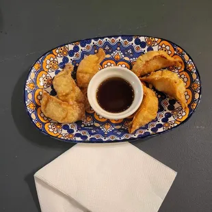 a plate of fried food with dipping sauce