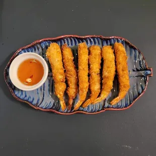a plate of deep fried fish sticks with dipping sauce