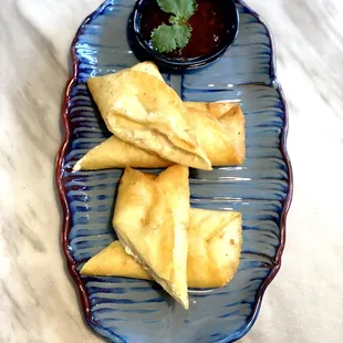 a blue plate with a small bowl of dipping sauce