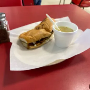 a sandwich and dipping sauce on a red table
