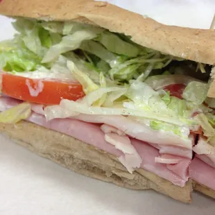 Ham &amp; turkey sandwich with provolone &amp;  American cheese American style on a wheat bun.