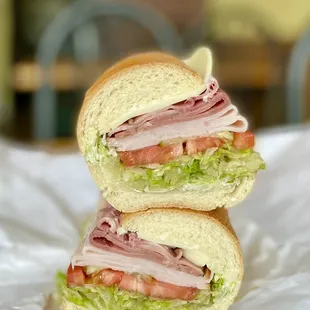 a cut in half sandwich with lettuce and ham