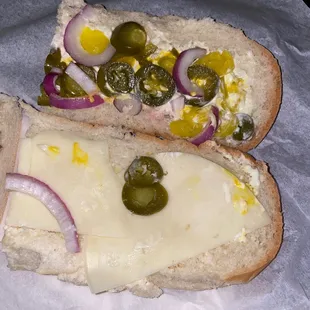two pieces of bread with cheese and pickles