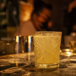 a close up of a glass of alcohol on a bar