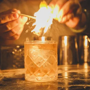 a person lighting a glass with a lighter