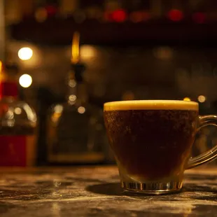 a cup of coffee on a bar counter