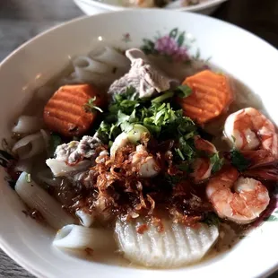 two bowls of seafood and noodles