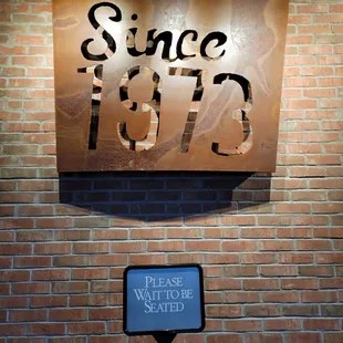 a sign on a brick wall