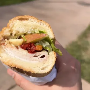 a person holding a sandwich in their hand