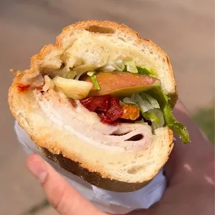 a person holding a sandwich in their hand