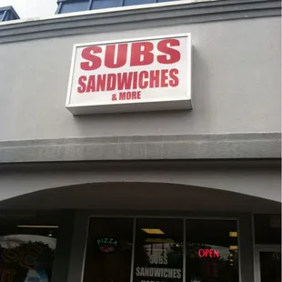 Subs, Sandwiches and More storefront sign