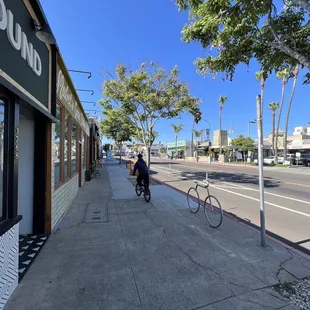 a person riding a bike on a sidewalk