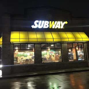 the front of a subway restaurant at night