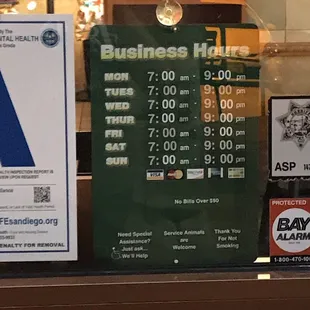 a business hours sign in a window